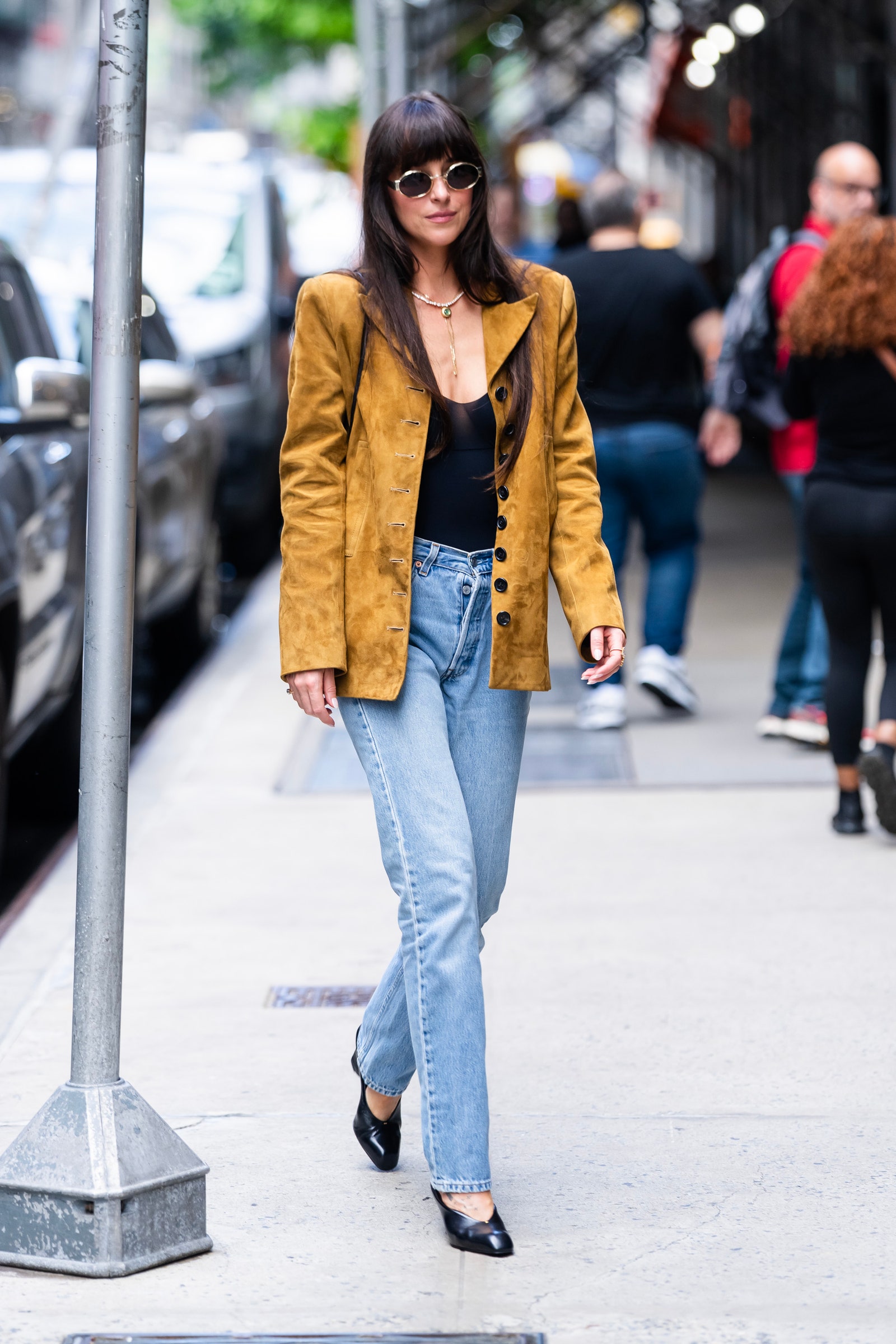 Images may contain Dakota Johnson Clothing Pants Jeans Adult Coat Accessories Glasses Shoes and Shoes